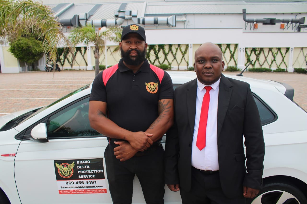 Bravo Delta Protection Services personnel beside a branded response vehicle